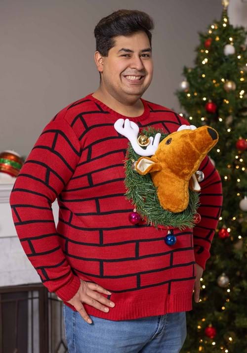 a man wearing a brick pattern sweater with a wreath and reindeer head design